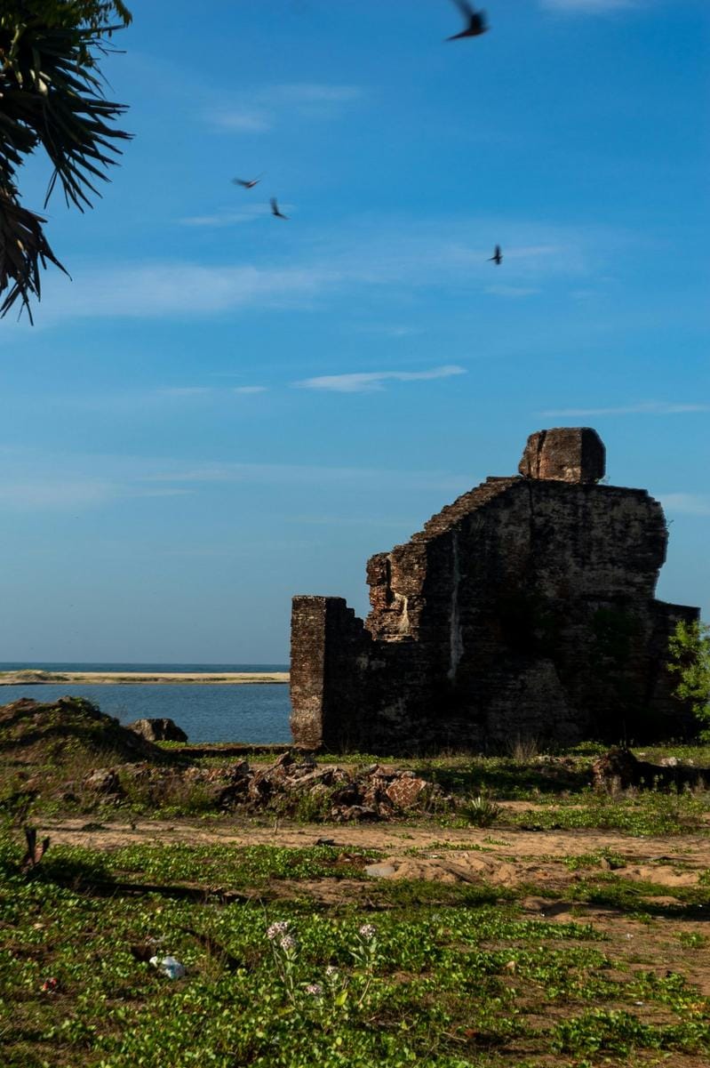 Ancient ruins of Kaş overlooking the Mediterranean Sea, with boats docked along the coast
