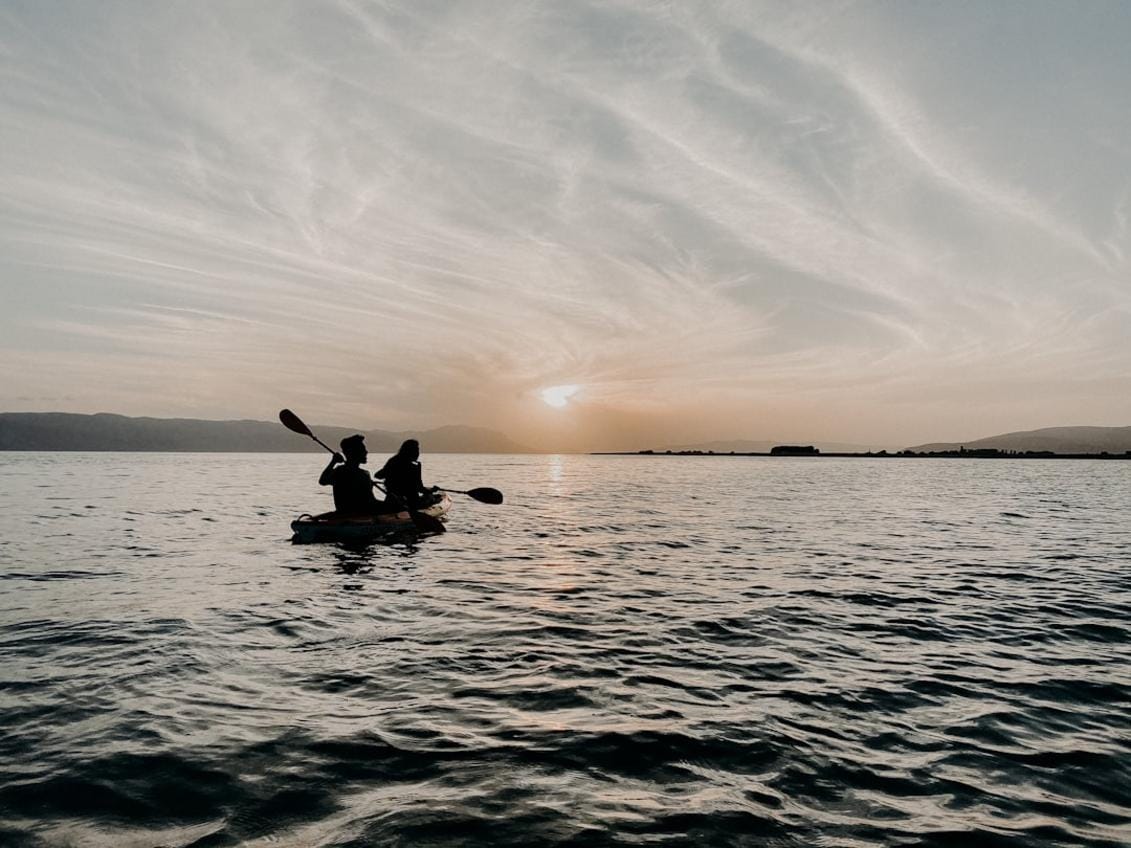 a group of tourists kayaking along a rugged Turkish coastline with lush scenery